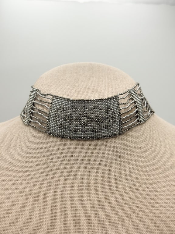 Antique 1900s Metal Beaded Moire Choker Necklace: Antique 1900s Metal Beaded Moire Choker Necklace having open-work bead design and moire ribbon details. Snaps closed at back. Measuring approximately 15 inches long.