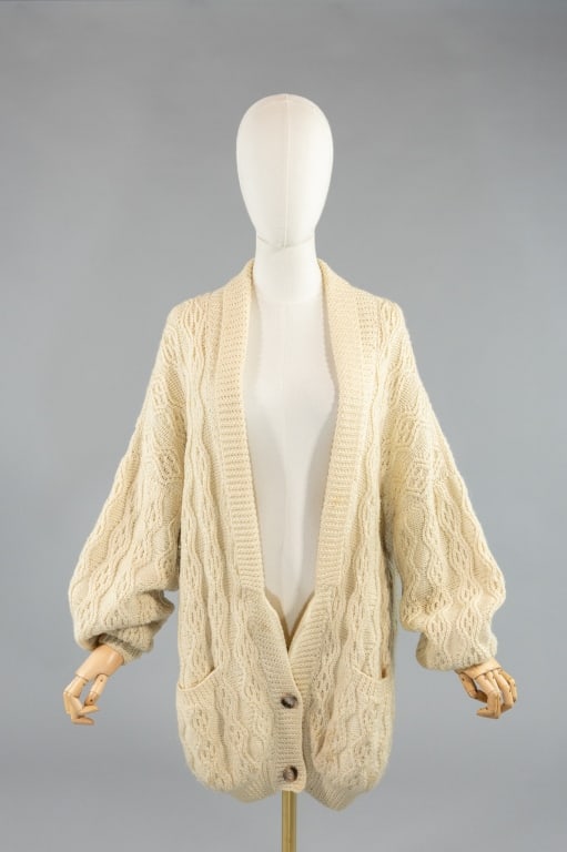 Vintage 1980s Cable Knit Cardigan Sweater Dress: Vintage 1980s Wool Cable Knit Cardigan Sweater Dress having plunging neckline with button closure at center front hem. Fully fashioned pockets at front with ribbed hem and sleeve cuffs. Measuring 46 i