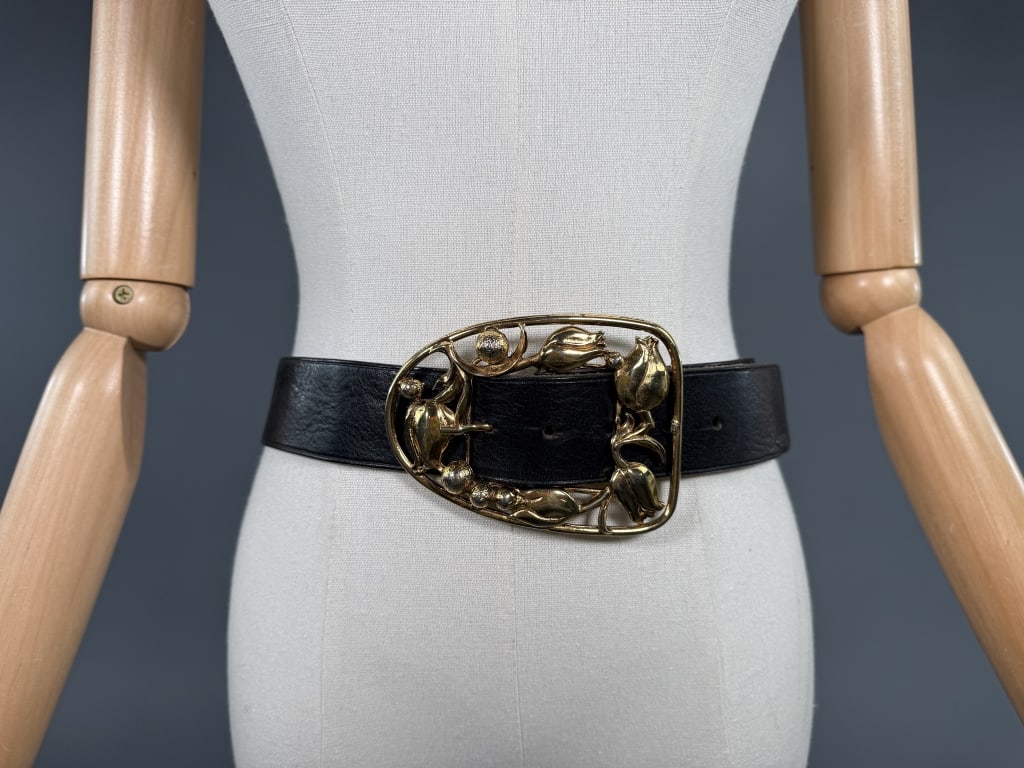 Vintage 1980s Geiger Gold Tone Floral Leather Belt: Vintage 1980s Geiger Gold Tone Floral Leather Belt having large floral open-work gold tone belt buckle and black leather belt. Adjustable from 30 inches to 33 inches. Light wear as shown.