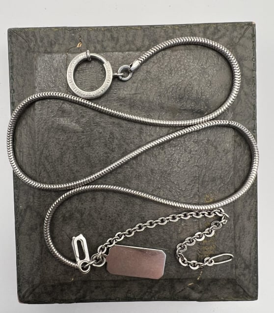 Art Deco Watch Chain w Sterling Silver Dog Tag: Art Deco Watch Chain w Sterling Silver Dog Tag. Tag is hallmarked, chain is unmarked and may be silver plate. Articulated watch chain set with Art Deco design large scale spring ring. Measures 17 inch