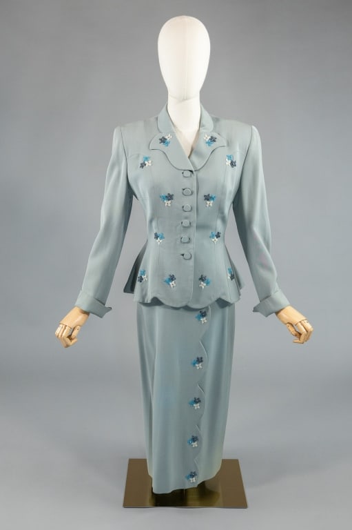 Vintage 1950s Gabardine Floral Beaded Skirt Suit: Vintage 1950s Blue Gabardine Floral Beaded 2 Piece Skirt Suit having fitted jacket with floral beaded accents throughout, fully lined. Skirt zips and buttons at side to close and has scallop and flora