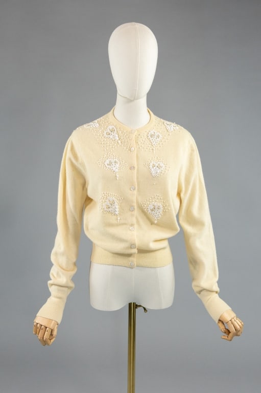 Vintage 1950s Wool Beaded Knit Cardigan Sweater: Vintage 1950s Wool Beaded Knit Cardigan Sweater having beaded details throughout with button front closure. Labeled Garland. Measuring 38 inch bust, 26 inch waist, 21 inches long, 25 inch sleeve lengt