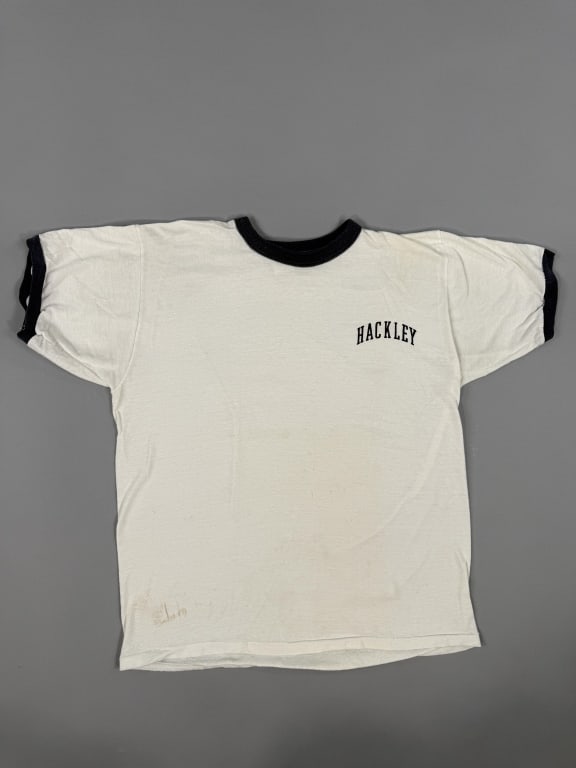 Vintage 1970s Hackley White Ringer Tee Shirt: Vintage 1970s Hackley Day Camp Blue Ringer Tee Shirt Top having graphic at chest & contrast ribbing at neck and sleeve cuffs. Russell Atheltic tag marked M. Measuring 20 inches flat across chest, 23 i