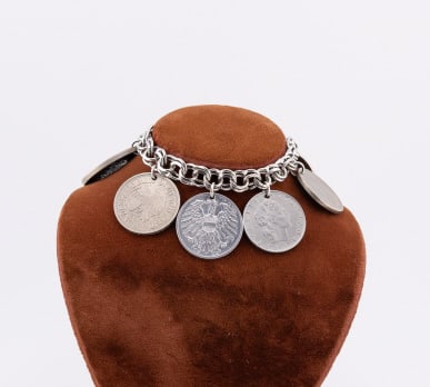 Rhodium Plated Sterling Silver Charm Bracelet: Rhodium Plated Sterling Silver Charm Bracelet w Collection of Vintage Coins. Clasp is hallmarked for sterling. Set with eight coins. Bracelet chain measures 7 inches in length.