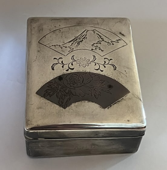 Antique Japanese Shakudo Chased Silver Box: Antique Japanese Shakudo Chased Silver Box. Signed on bottom. Silver mounted over wooden case. Scene of fan and mount Fuji. Measures 1.75 x 4.25 x 3.5 inches approximately.