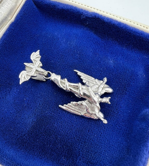 Figural Sterling Fallen Angel Necklace Pendant: Figural Sterling Fallen Angel Necklace Pendant. Finely detailed sterling silver necklace pendant with bat and Maltese cross design on the bail. Suspended with a fallen angel wrapped in draped fabric.