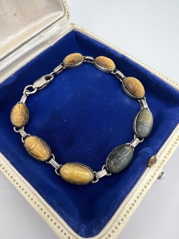 Egyptian Revival Sterling & Stone Scarab Bracelet: Vintage Egyptian Revival Sterling & Stone Scarab Bracelet. Articulated panel bracelet set with tiger's eye and other carved hardstone scarabs. Hallmarked. Measures just under 8 inches in length.