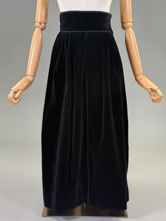 Vintage 1970s Saint Laurent Black Velvet Skirt: Vintage 1970s Saint Laurent Rive Gauche Black Velvet Skirt having wide waistband with button and zip closure at side with single pocket and corded details throughout, fully lined. Marked size 38 - Mea