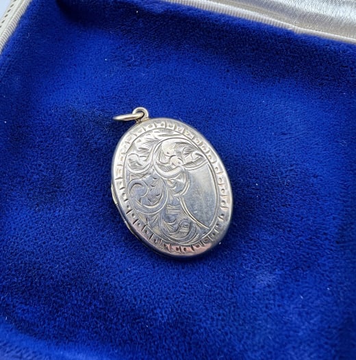 Antique 19th C English 9kt Gold Locket Pendant: Antique 19th C English 9kt Gold Locket Pendant. Front with chased scrollwork design. Back is hallmarked 9ct and SIL. Measures 1.25 inches in length.