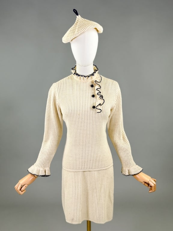 Vintage 1970s Knit 3 Pc Sweater Skirt Hat Set: Vintage 1970s Knit 3 Pc Sweater Skirt Hat Set sweater having ruffle and button detail at front and back neck zip closure. Skirt having elastic waist. Hat having beret style. Sweater measuring 36 - 42