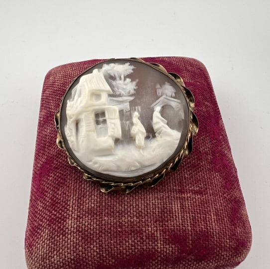 Antique 19th C Gold Filled Scenic Cameo Brooch: Antique 19th C Gold Filled Scenic Cameo Brooch. Victorian era natural shell cameo with hand carved scene of houses and couple. Gold filled setting / frame. Measures 1.5 inches in diameter.