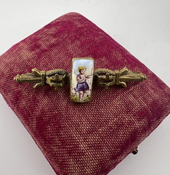 Antique 19th C Brooch w Enamel Plaque of Cupid: Antique 19th C Gold Filled Brooch w Enamel Plaque of Cupid at Center. Plaque in the style of the Vienna Austria enamel work of the 19th century. Scene of cupid with bow and arrow. Measures 2.25 inches