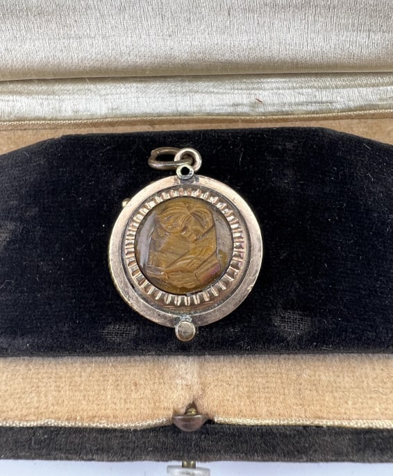 Antique 19th C Tiger Eye Locket w Unique Mechanism: Antique 19th C Victorian Era Tiger's Eye Locket Necklace Pendant w Unique Opening Mechanism. Gold filled frame set with a carved tiger's eye cameo on the front and round panel on the back. Measures ap