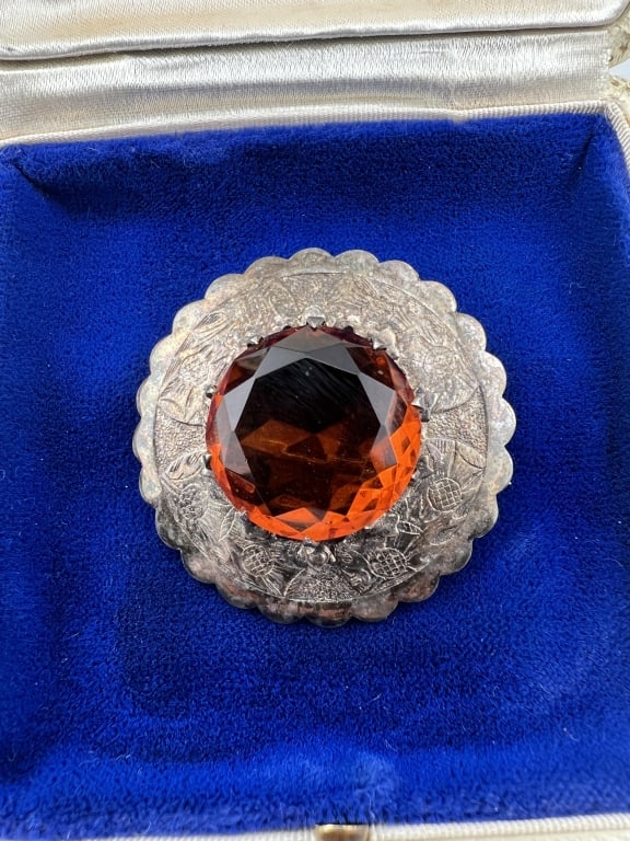 Antique Scottish Thistle Motif Kilt Clip Brooch: Antique Scottish Thistle Motif Kilt Clip Brooch. Silver, thistle motif, set with madeira citrine tone crystal at center. Unmarked. Measures just over 1.5 inches in diameter.