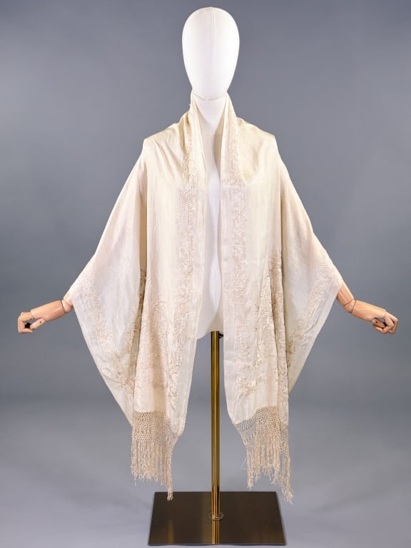 Antique 1920s Ivory Embroidered Piano Shawl Scarf: Antique 1920s Ivory Embroidered Piano Shawl Scarf having floral embroidery throughout and macrame fringed edges. Measuring approximately 76 inches long by 22 inches wide with 8 inch long fringe. Small