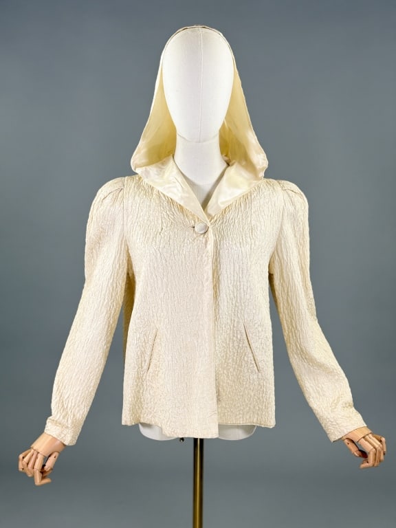 Vintage 1940s Ivory Floral Quilted Hooded Jacket: Vintage 1940s Ivory Floral Quilted Hooded Jacket having floral quilting throughout with puffed sleeves, welt pockets, and hood at neck with single button closure, fully lined. Measuring free bust, 23