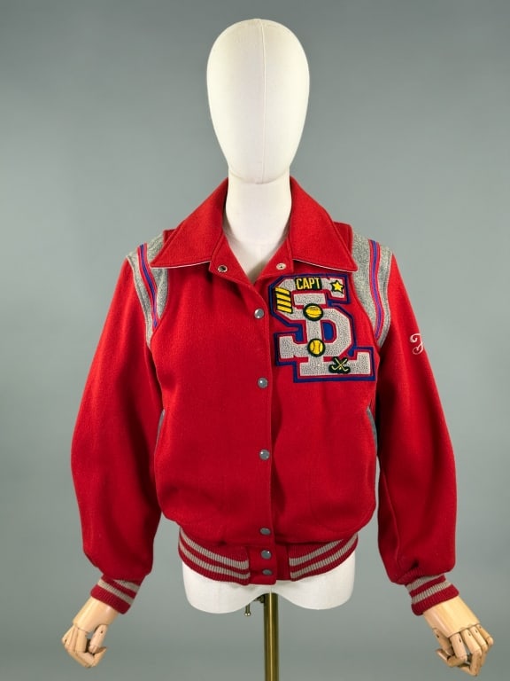 Vintage 1980s Red Wool Collegiate Varsity Jacket: Vintage 1980s Red Wool Collegiate Varsity Jacket having embroidered patch at front chest, embroidery at sleeve and back, with snap front closure and leather welt pockets at front, fully lined througho