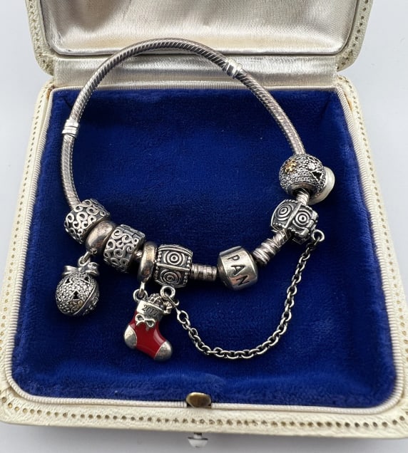 Sterling Silver Pandora Bracelet w Bead Charms: Sterling Silver Pandora Bracelet w Bead Charms. Sterling silver bangle bracelet with five beads / charms, snap on safety chain and branded PANDORA clasp. Signed PANDORA. Hallmarked for sterling. Measu