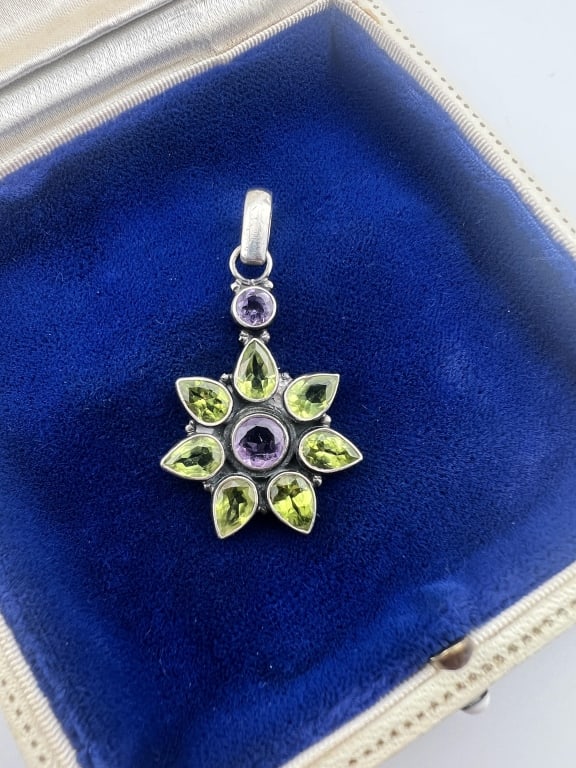 Sterling Amethyst & Peridot Necklace Pendant: Sterling Silver Amethyst & Peridot Necklace Pendant. Starburst or flower motif. Hallmarked on the back. Measures 1.75 inches in length.