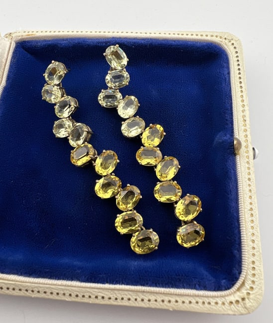 Gold Over Sterling Silver Citrine Topaz Earrings: Pair of Gold Over Sterling Silver Citrine Topaz Earrings. Hallmarked 925 on the back. Prong set citrine and topaz oval cut gemstones. Each measures just over 2.5 inches in length. Stone may be enhance