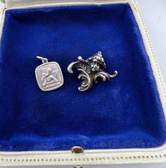 Antique 19th C Sterling Silver Cherub Pendant: Antique 19th C Sterling Silver Cherub Necklace Pendant. Measures 1 inch in width. Together with a Silver Raffaello Cherub Pendant Charm.