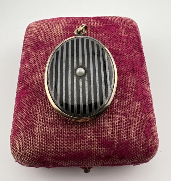 Antique Art Deco Gold Filled Black Enamel Locket: Antique Art Deco Gold Filled Black Enamel Locket Necklace Pendant. Gold filled setting with black enamel stripes down the front and center with a pearl. Interior with original photos. Measures 2 inche