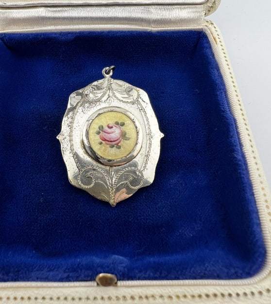 Estate Sterling Silver & Guilloche Enamel Locket: Estate Sterling Silver & Guilloche Enamel Locket Necklace Pendant. Stamped STERLING inside. Front with hand painted floral motif enamel plaque. Measures 1.75 inches in length.