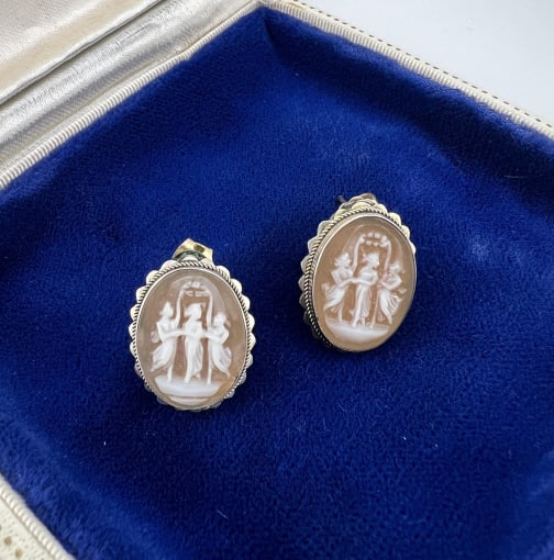 Pair Sterling & Shell Cameo Three Grace Earrings: Pair Sterling & Shell Cameo Three Grace Earrings. Pair of sterling silver framed earrings with hand carved natural shell cameos depicting the three graces. Each measures .75 of an inch in length. Like