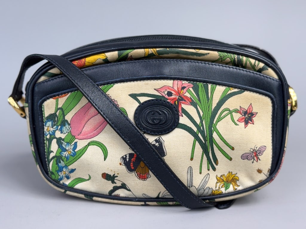 Vintage Gucci Flora Canvas Leather Cross Body Bag: Vintage Gucci Flora Canvas Leather Cross Body Bag having canvas body with flora print throughout and leather details, zips closed with interior zip pocket and front outer pocket. Measuring approximate