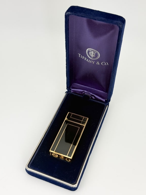 Tiffany & Co Black Enamel Lighter in Original Box: Tiffany & Co Black Enamel Lighter in Original Box. Gold tone with black enamel. Lighter measures 2.25 inches and stamped TIFFANY on the bottom as well as marked TIFFANY & CO, box measures 4.75 inches 