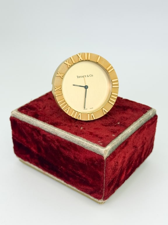 Vintage Gilt Metal Tiffany & Co Mini Travel Clock: Vintage Gilt Metal Tiffany & Co Mini Travel Clock. With Roman Numerals. Signed on face, Swiss Movement, signed on the back as well. Measures just over 1.5 inches in diameter.