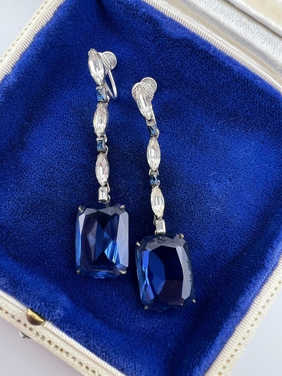 Pair Antique Art Deco 10kt Gold Sapphire Earrings: Pair of Antique Art Deco 10kt White Gold & Blue Sapphire Pendant Earrings. Hallmarked 10kt. Synthetic sapphires and paste navettes. Screw backs. Each measures just under 2.25 inches in length.
