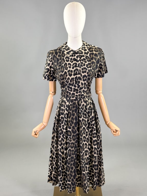 Vintage 1950s Cotton Leopard Print Day Dress: Vintage 1950s Cotton Leopard Print Day Dress having short sleeves, small collar, button front closure, and pleats through waist. Labeled Best & Co Fifth Ave New York. Measuring 36 inch bust, 26 inch w