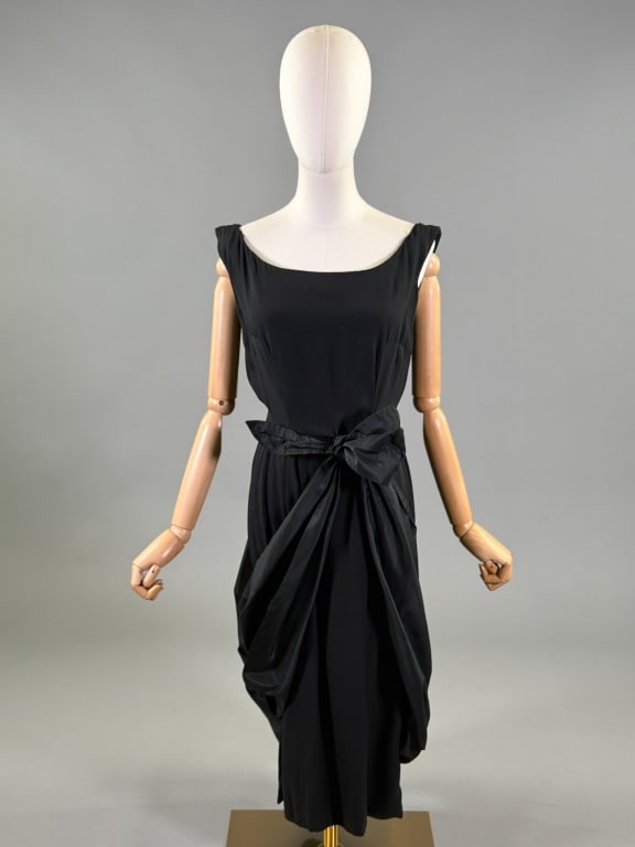 Vintage 1950s Patullo Jo Copeland Black Silk Dress: Vintage 1950s Patullo Jo Copeland Black Silk Dress having taffeta bow drape detail through front and back with center back zip closure. Labeled Patullo Jo Copeland. Measuring 36 inch bust, 26 inch wai