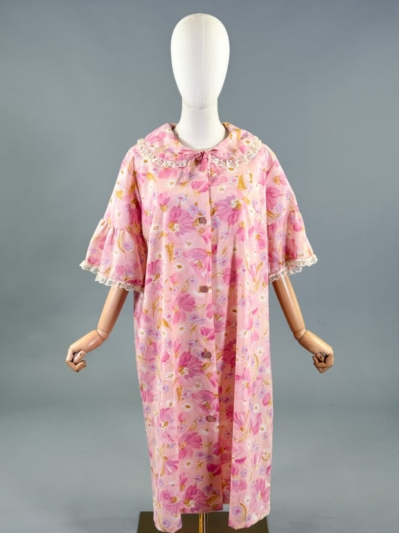 Vintage 1960s Floral Print House Coat Robe Jacket: Vintage 1960s Floral Print House Coat Robe Jacket having Peter Pan collar at neck, lace details & button front closure with single side pocket. Labeled Charm Maid - marked size 18. Measuring 48 inch b