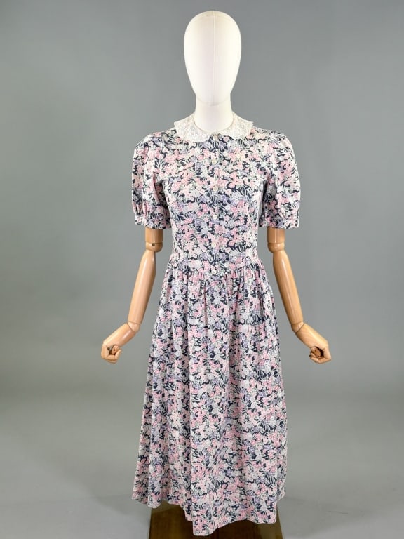 Vintage 1980s Laura Ashley Floral Print Dress: Vintage 1980s Laura Ashley Floral Print Dress having lace collar, short puffed sleeves, button front closure, and two front pockets. Labeled Laura Ashley - marked size US 6. Measuring 32 - 33 inch bus