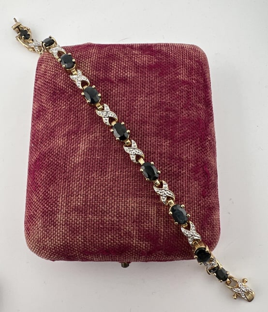 Gold Over Sterling Diamond & Sapphire Bracelet: Gold Over Sterling Silver Diamond & Sapphire Bracelet. Articulated tennis bracelet, yellow gold over sterling silver, set with accent diamond and twelve sapphires. Main clasp with safety clasp on eith
