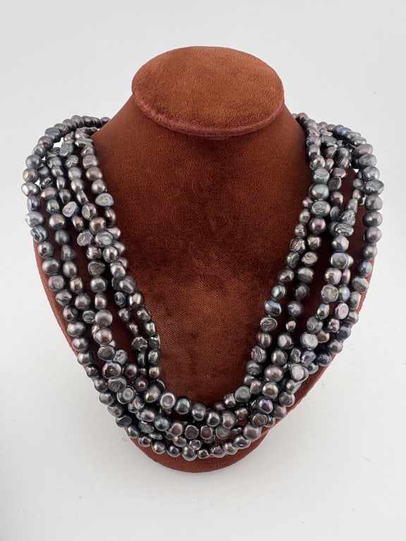 Five Strand Baroque Black Pearl Necklace: Five Strand Baroque Black Pearl Necklace. Measures 18 inches in length. Set with floral motif clasp.
