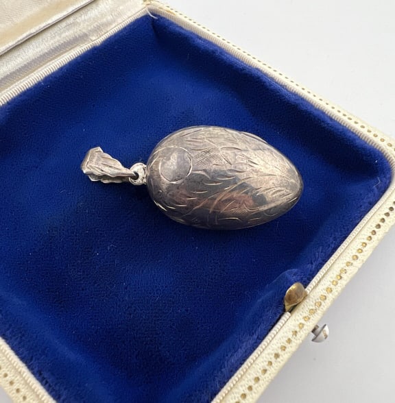 Vintage Sterling Silver Egg Shaped Locket Pendant: Vintage Sterling Silver Egg Shaped Locket Necklace Pendant. Chased scrollwork design on the surface. Hallmarked. Measures just over 1.75 inches in length.