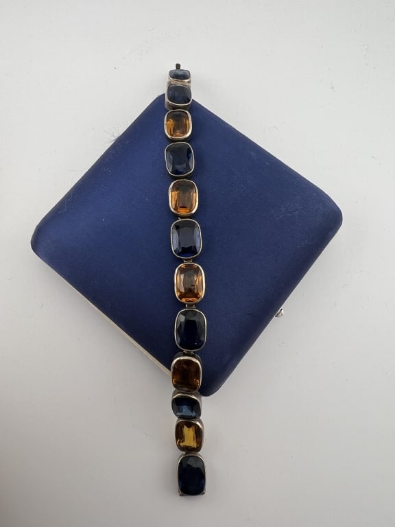 Sterling Silver & Crystal Art Deco Tennis Bracelet: Sterling Silver & Crystal Art Deco Tennis Bracelet. Articulated panel bracelet with citrine and sapphire tone crystals. Hallmarked. Measures 7.25 inches in length.