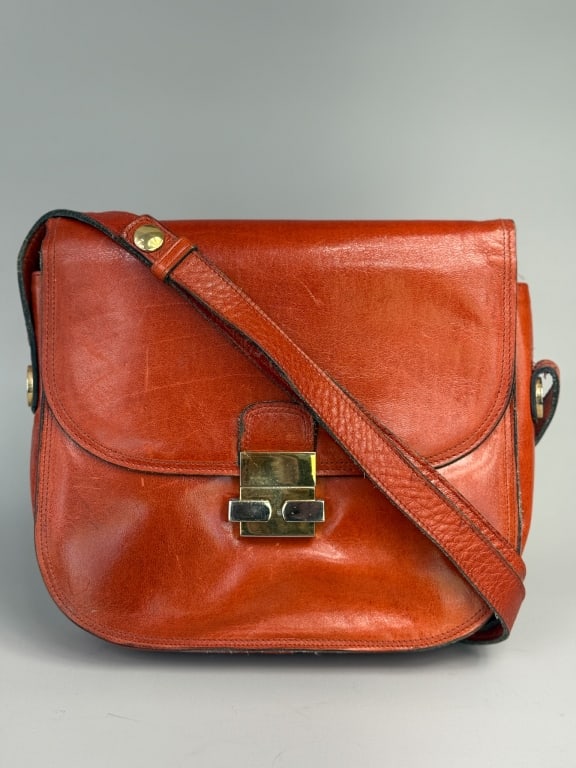 Vintage 1960s Saks Fifth Avenue Leather Saddle Bag: Vintage 1960s Saks Fifth Avenue Leather Saddle Bag having duo tone gold and silver hardware with lock closure at front and adjustable cross body strap. Labeled Saks Fifth Avenue Italy. Measuring appro