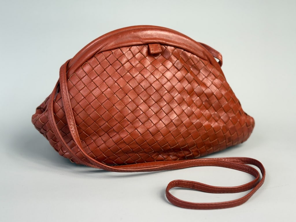 Vintage 1960s Saks Fifth Avenue Woven Leather Bag: Vintage 1960s Saks Fifth Avenue Woven Leather Bag having metal frame closure and thin cross body strap. Labeled Saks Fifth Avenue Made in Italy. Measuring 11 inches wide by 8 inches tall by 3 inches d