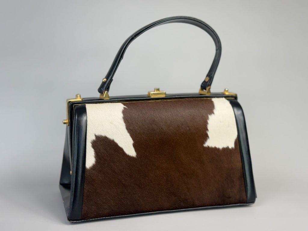 Vintage 1960s Cowhide Leather Doctor Hand Bag: Vintage 1960s Cowhide Leather Doctor Hand Bag having gold tone lock closure at top with metal frame. Measuring approximately 10 inches wide by 7 inches tall by 5 inches deep with a 5 inch strap drop. 