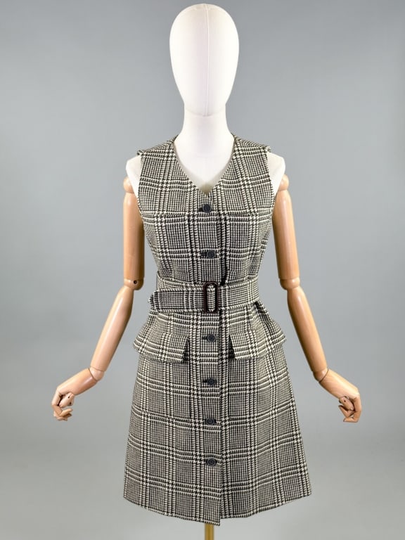 Vintage 1990s Isaac Mizrahi Wool Houndstooth Dress: Vintage 1990s Isaac Mizrahi Wool Houndstooth Dress having sleeveless armholes and button front closure with four front patch pockets and belt at waist. Labeled Isaac Isaac Mizrahi - marked size 4. Mea