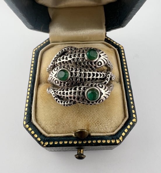 Sterling Silver & Emerald Snake Motif Ring: Sterling Silver & Emerald Snake Motif Ring Design of three snakes coiled together with textured finish for the scales. Each set with an emerald in its head. Hallmarked 925. Ring size 7.75. Stones test