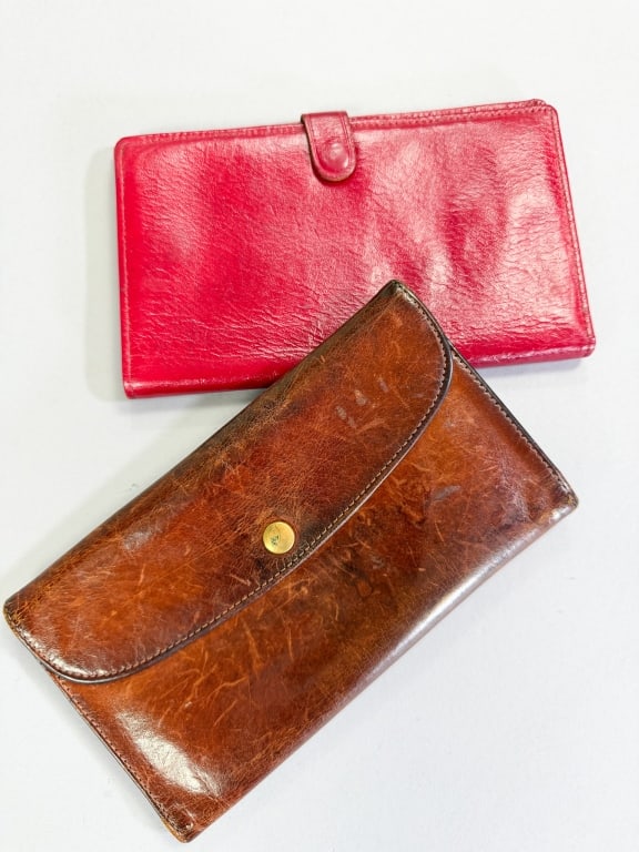 Two Vintage Leather Wallets Including Coach: Two Vintage Leather Wallets including Coach having one red with travel print inside. Measuring 7 inches by 4.5 inches. One Coach wallet measuring 7.5 by 4 inches both with general wear throughout as s
