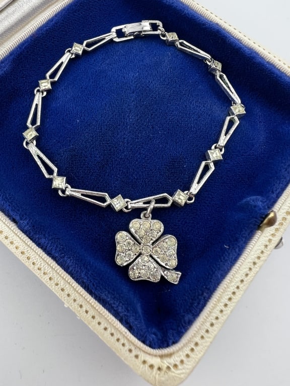 Antique Art Deco Sterling Bracelet w Clover: Antique Art Deco Sterling Bracelet w Clover. Articulated sterling silver bracelet with clover pendant / charm that is set with paste stones. Stamped. Bracelet measures just under 7 inches in length.