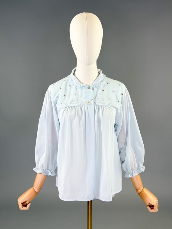 Vintage 1950s Nylon Knit Floral Bed Jacket Top: Vintage 1950s Nylon Knit Floral Bed Jacket Top having floral embroidery at front yoke with buttons at neck, marked size Medium. Measuring free bust, 23 inches long, 17 inch sleeve length.