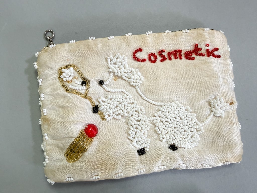 Vintage 1950s Beaded Poodle Cosmetic Bag: Vintage 1950s Beaded Poodle Cosmetic Bag having zippered closure and beading throughout. Measuring approximately 6 inches by 4 inches. General wear throughout as shown.