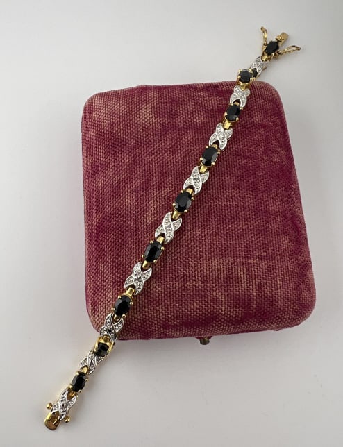 Gold on Sterling Sapphire Diamond Tennis Bracelet: Gold on Sterling Sapphire Diamond Tennis Bracelet. Gold over sterling silver articulated bracelet with sapphires and diamond accents. Hallmarked 925. Set with two safety clasps. Measures 7.5 inches in